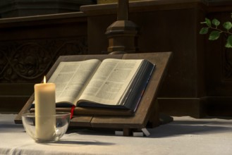 Church altar with Bible with burning candle