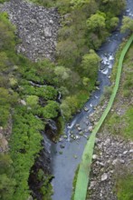 Narrow bridge across a river amidst forest and rocky terrain, Dashbashi gorge and waterfall, Khrami
