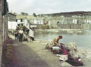 People on coastal path at seaside village of Mousehole, Cornwall, England, UK c 1960