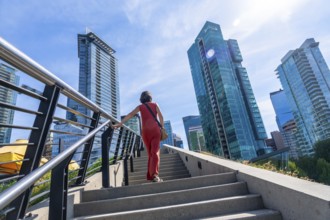 Tourist walking up stairs with skyscrapers and modern architecture in the background, enjoying a