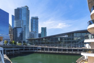 Glass skyscrapers and the vancouver convention centre are reflecting on the green water with a