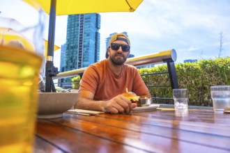 Tourist is having a burger and beer at an outdoor restaurant in vancouver, british columbia, with