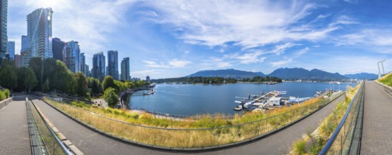 Panoramic view of vancouver's modern skyline rising above a picturesque waterfront, showcasing lush