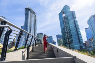 Businesswoman climbing stairs with modern skyscrapers in background in vancouver, british columbia,
