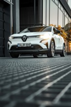 Renault car in front of reflecting windows at sunset in urban environment, Deer e-car sharing,