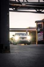 Car in evening lighting on an urban sidewalk surrounded by lanterns, Deer E-Carsharing, Renault