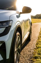 A modern car shines in sunlight driving across a country road, Deer E-Carsharing, Renault Megane,