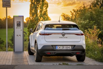 An electric car parks peacefully at a charging station in the evening light, Deer E-Carsharing,