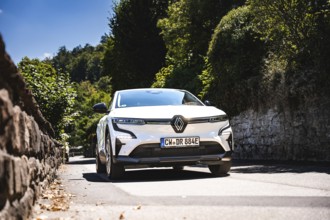 White car driving down a tree-lined stone road, Deer E-Carsharing, Renault Megane, Calw, Germany
