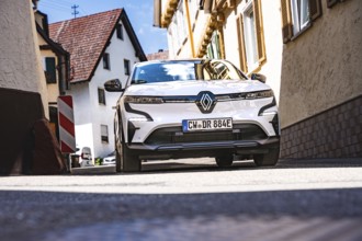 Car driving through a narrow sunny street in a city, Deer e- Carsharing, Renault Megane, Calw,