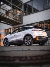 Modern car parked in front of a building in the warm evening light, Deer E-Carsharing, Renault
