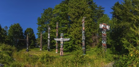 Totem poles rising against a backdrop of lush greenery and blue sky, reflecting the rich history