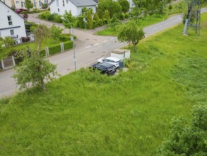 Drone image of a residential area with houses, street and lots of vegetation, deer e-car sharing,