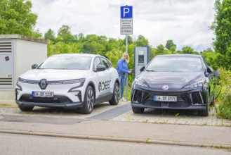 Electric cars park with a view of charging station, surrounded by green vegetation, Deer
