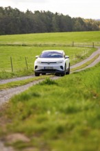 SUV on dirt road through green fields, peaceful natural scenery, deer e-car sharing, VW ID4, Calw,