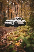 SUV in an autumn-colored forest on a narrow path, Deer E-Carsharing, VW ID4, Calw, Germany