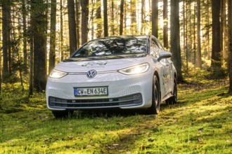 A white car in the forest with sunbeams, license plate CW EN 634E, Deer E-Carsharing, VW ID3, Calw,