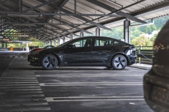 Black car in a covered parking lot with a view of nature, Deer e- car sharing, Tesla Model 3, Calw,