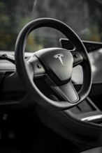 Close-up of a black steering wheel in a modern vehicle interior, Deer e-Carsharing, Tesla Model 3,
