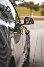 Close-up view of a black car with side mirror on a road, Deer e-Carsharing, Tesla Model 3, Calw,