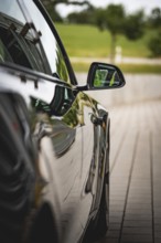 Side view of black car with reflecting side mirror, Deer E- car sharing, Tesla Model 3, Calw,