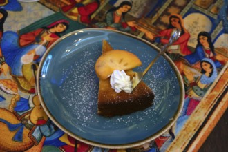 Piece of cake decorated with a mango slice served in a Persian café, Fürth, Middle Franconia,