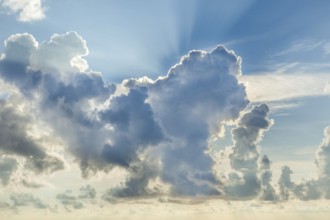 A stunning display of colorful clouds fills the sky as the sun sets, creating a dramatic and scenic