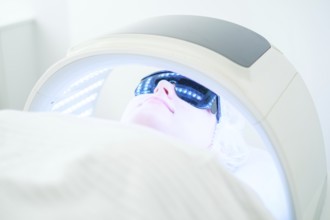 A client enjoys non-invasive LED light therapy for acne during a relaxing facial cleansing session