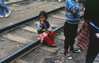 Little girl sitting on railroad tracks, Agua Caliente, Andean Highlands, Peru, South America,