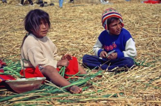 Children sitting on a floating Uro island in Lake Titcaca, Peru, South America, September 1997,