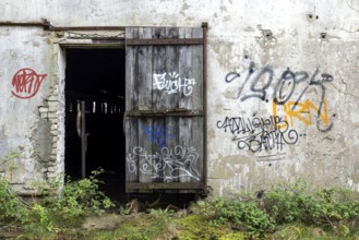 Wall with Grafity and Gate, dilapidated complex of a former agricultural production cooperative of
