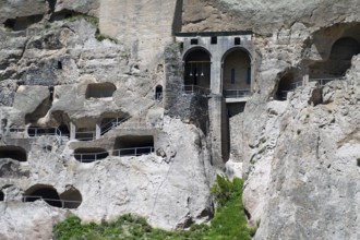 Old rock monastery carved into a rock wall. Impressive architectural structure with caves and