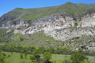 A rocky cliff with numerous caves carved into the rock face, cave town, cave monastery, Kura River,