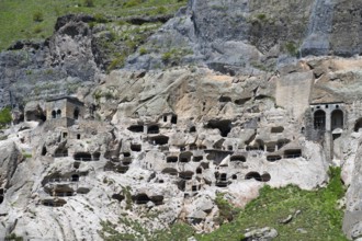 A rocky wall with numerous cave openings carved into the stone, cave town, cave monastery, Vardzia,
