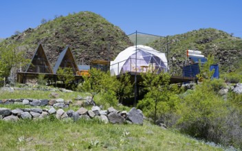 Campsite with huts and tents nestled in rolling green countryside, Vardzia Glamping, Vardzia,