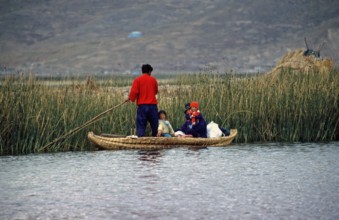 Young family with young children in a reed boat, Lake Titicaca, Puno, Andean Highlands, Peru, South