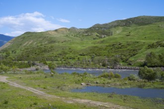 Green hills and a calm river under clear sky, Kura River between Akhaltsikhe, Akhaltsikhe and