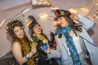 Three diverse young women happily celebrating and dancing together at a lively party, holding