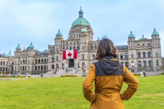 Tourist standing in front of the impressive parliament buildings, proudly displaying the canadian