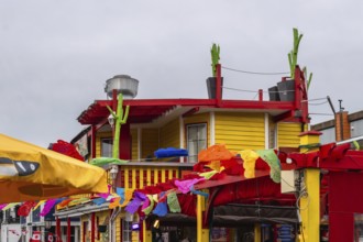 Vibrant mexican restaurant decorated with colorful papel picado and cacti, celebrating summer in