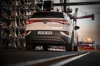 White car against an urban backdrop at sunset, VW ID4 electric car, Deer Carsharing, Calw, Germany