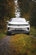 White car on a forest road in autumn surroundings, VW ID4 electric car, Deer Carsharing, Calw,