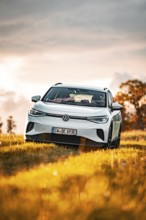 A white Volkswagen in a field at sunset, VW ID4 electric car, Deer Carsharing, Calw, Germany