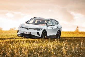 White car standing in a field at sunset, VW ID4 electric car, Deer Carsharing, Calw, Germany