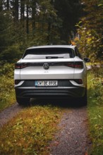 Rear view of a white Volkswagen on a forest road, VW ID4 electric car, Deer Carsharing, Calw,