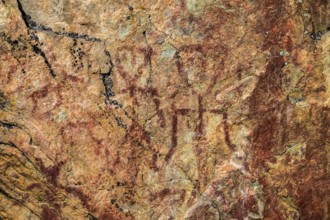 Prehistoric rock rock painting in reddish brown on a textured surface Rock paintings from