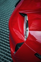 Close-up of the front end of a red Porsche with focus on headlight design, Porsche Taycan, Deer