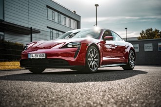 Red sports car outside a modern building in sunshine, Porsche Taycan, Deer Carsharing, Calw,