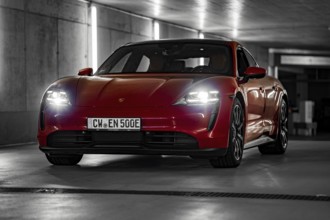 Red Porsche Taycan in underground car park at night with bright headlights and urban look, Porsche