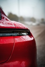 Close-up of a red Porsche with wet body and shiny rear light, Porsche Taycan, Deer Carsharing,